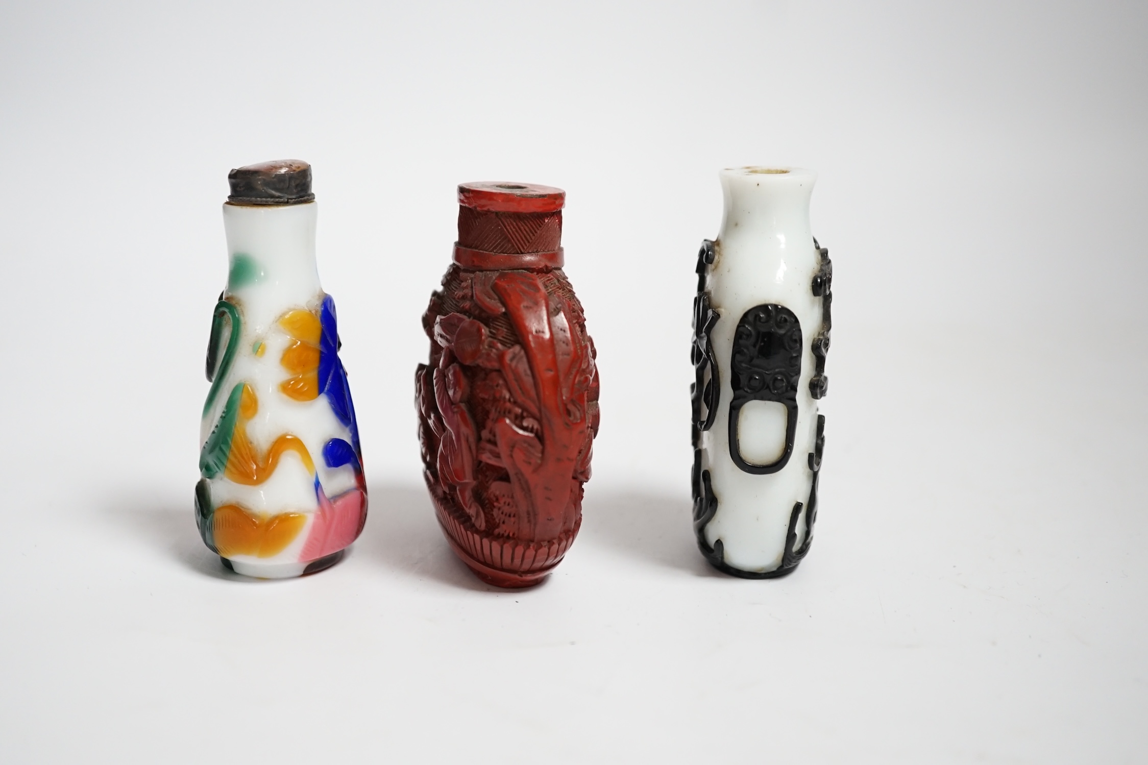 Three Chinese snuff bottles including a 19th century cinnabar lacquer ‘boys’ snuff bottle, largest 7cm high